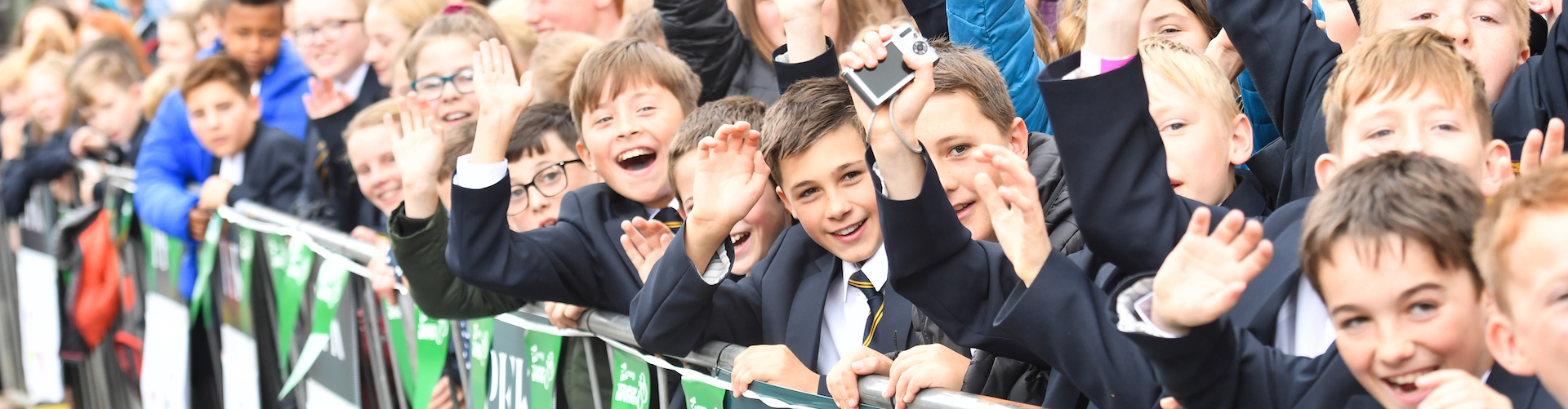 School children wave on cyclists during the Tour of Britain.